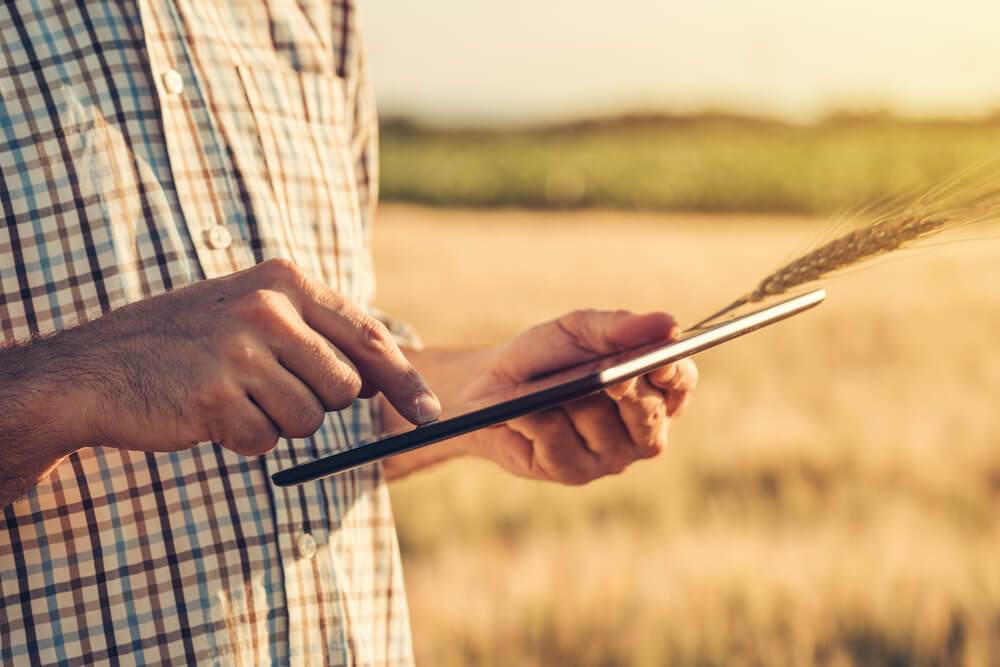 farmer holding tablet computer in field